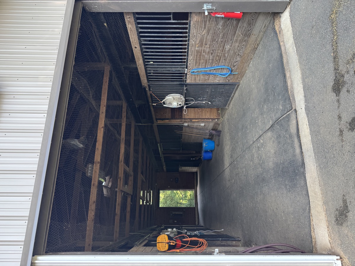 The main barn seen from the sliding door, looking through the aisle to the paddocks beyond